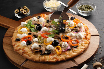Pizza with mozzarella ,olives and mushroom. Italian cuisine. Ingredients for making pizza on a black background.  Top view.Concept for advertising restaurants or pizzerias.