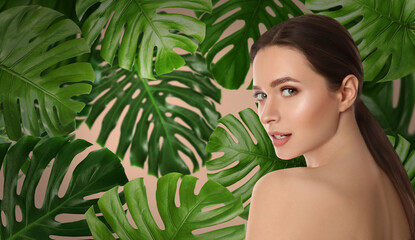 Beautiful young woman and tropical leaves, banner design. Spa portrait