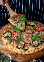Pizza with eggplant ,olives and mushroom. Italian cuisine. Ingredients for making pizza on a black background. Top view.Concept for advertising restaurants or pizzerias.