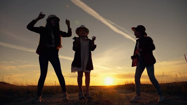 Happy children concept. Silhouette of cheerful children. Children dance at sunset. Happy children are having fun in park at sunset. group of people are having fun, dancing together. Happy children