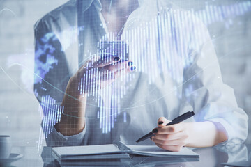 Double exposure of business theme sketch hologram and woman holding and using a mobile device.