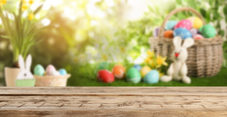Empty wooden surface and wicker basket with colorful Easter eggs on background. Banner design