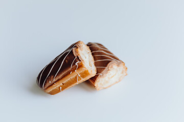 Traditional french dessert. Isolated eclair with custard and chocolate icing on white background....