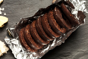handmade chocolates without heat treatment with air amaranth. lie on a black granite table. raw food diet concept.