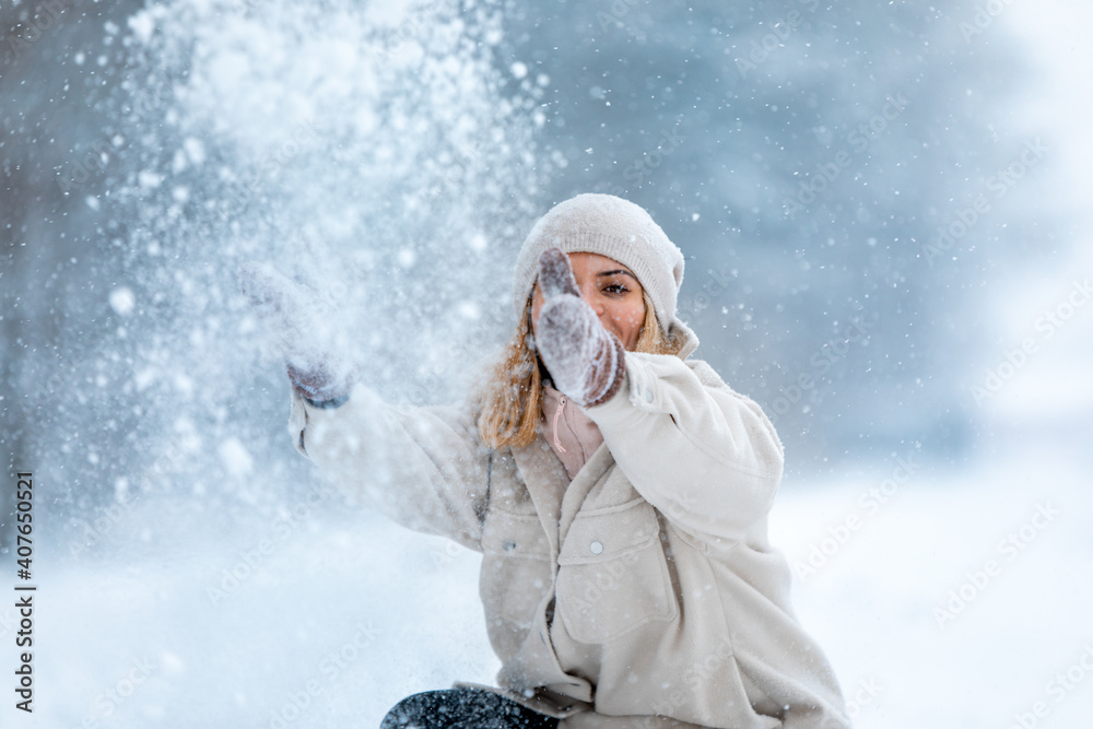 Wall mural Enjoying winter time woman playing with snow