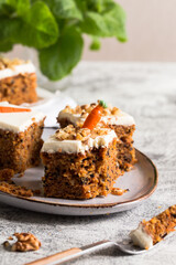 Fototapeta na wymiar pieces of carrot cake with walnuts with icing cream on a light background. tinting. selective focus
