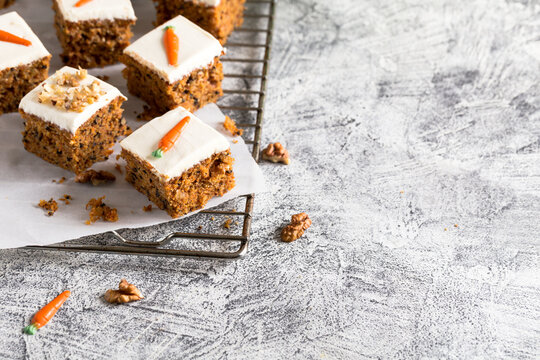 pieces of carrot cake with walnuts with icing cream on a light background. tinting. selective focus