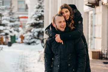A loving couple in a gentle embrace against the background of a snowy city