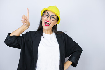 Young architect woman wearing hardhat smiling having an idea