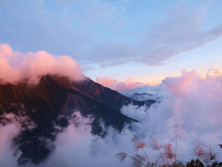 clouds over and around the mountains in the twilight