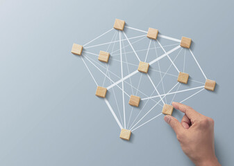 Human resources management, teamwork management or business strategy to success concept. Hand is arranging wooden blocks in low polygon diamond shape network on gray background.