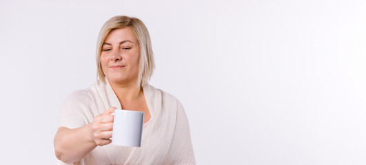 Banner. Caucasian woman holds out a cup of tea to the camera. White background and blank advertising space.