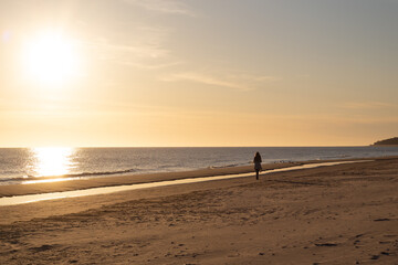 Fototapeta na wymiar Sonnenaufgang auf Usedom Frau spaziert am Strand entlang
