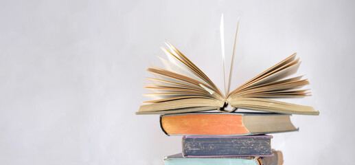 opened book and stack of book,reading,education,home office, back to school concept, narrow...