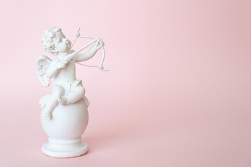 figurine of an angel Cupid with a bow on a pink background. Valentine's Day. - Powered by Adobe