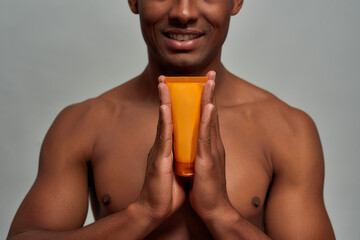 Smile on person face while holding a face care product
