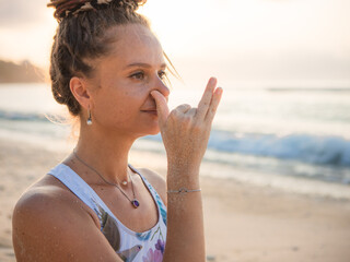 Woman's face close up. Yogi woman practicing Anuloma viloma Pranayama, Alternate Nostril Breathing....