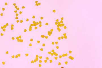 Pink background with gold hearts, sequins. The concept of the Valentine's Day theme. Postcard, template, background