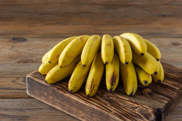 Ripe bananas on woodn background. Tasty healthy tropical fruits.