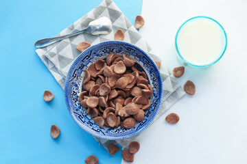  Top view of chocolate corn flakes in a bowl on color background 