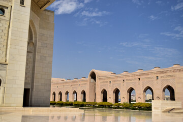 Fototapeta premium A sequence of arches in a courtyard in Sultan Qaboos Grand Mosque. The sky is blue. Muscat, Oman.