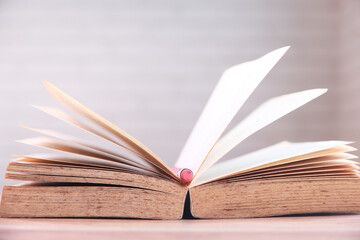 open book and a pencil on wooden table 