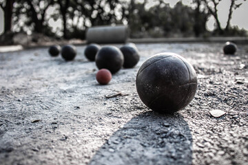 Petanque balls are placed on a stone petanque field.