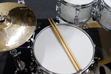 Drums conceptual image. Picture of drums and drumsticks lying on snare drum