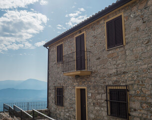 old stone house with brown and yellow doors and windows in mediterranean style at romantic mountain village Baunei Ogliastra, Sardinia, Italy