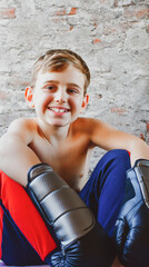 Portrait of young Shirtless  smiling boy boxer with blonde hair wearing boxing gloves workout at home 