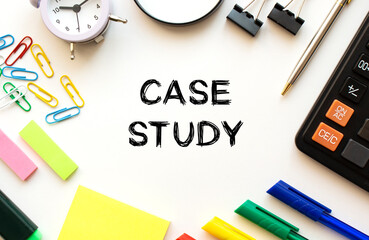Office desk table with calculator, pens and other stationery. Text on the CASE STUDY.