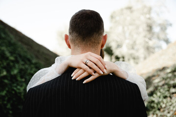 rich groom and bride walk beautifully along the road through the park overgrown with ivy. wedding day of a young family. newlyweds. the beginning of marriage. strong family. romantic relationship