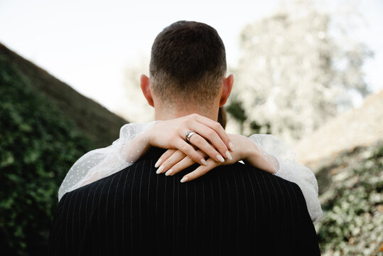 rich groom and bride walk beautifully along the road through the park overgrown with ivy. wedding day of a young family. newlyweds. the beginning of marriage. strong family. romantic relationship