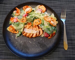 food on a plate caesar salad pasta with shrimp