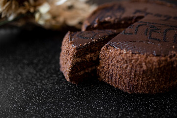 Piece of cake. Sliced tasty chocolate cake. Chocolate cake with a cut piece on blurred background, closeup