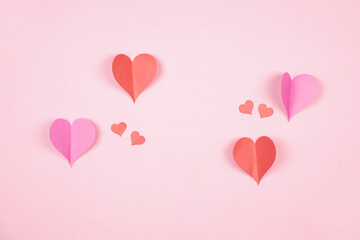 Fototapeta na wymiar Heart shaped paper sticked on pink background. Emblem of love for happy women, beloved mother, birthday cards and valentine greeting designs. Valentine's day backgrounds. Templates to convey our love.