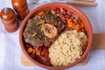 Ossobuco. Veal (beef) shanks with saffron risotto in milanese, gremolata and sauce. Traditional Italian dish. Close-up.