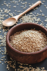 Brown rice in a wooden bowl with wooden or bamboo spoon