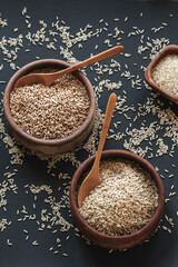 Set of different types of rice and cereals in wooden bowls and bamboo spoon