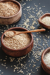 Set of different types of rice and cereals in wooden bowls and bamboo spoon