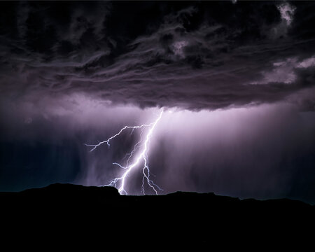 Powerful lightning storm in the American Southwest. One sees the silhouette of the hills on bottom, the lightning, and the cumulonimbus clouds. 
