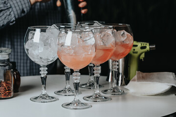 Cocktails with champagne in wine glasses on the bar table in the pub or restaurant with the bartender. 