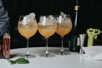 Cocktails with champagne in wine glasses on the bar table in the pub or restaurant with the bartender. 