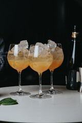 Cocktails with champagne in wine glasses on the bar table in the pub or restaurant with the bartender. 