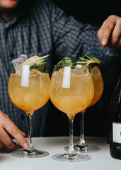 Cocktails with champagne in wine glasses on the bar table in the pub or restaurant with the bartender. 