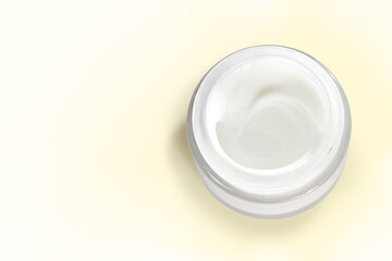 Obraz na płótnie Canvas Jar of organic skin care cream isolated on a pale yellow background with clipping path. Copy space