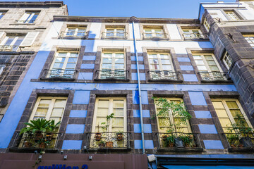 Fototapeta na wymiar typical facades of houses in the streets of Clermont Ferrand, Auvergne (France). Here, the 