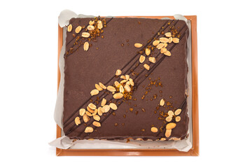 chocolate cake with nuts and caramel in a cardboard box