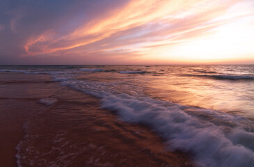 Obraz premium Sunset over the sea shore, sandy beach, colorful sky