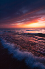 Fototapeta na wymiar Sunset over the sea shore, sandy beach, colorful sky